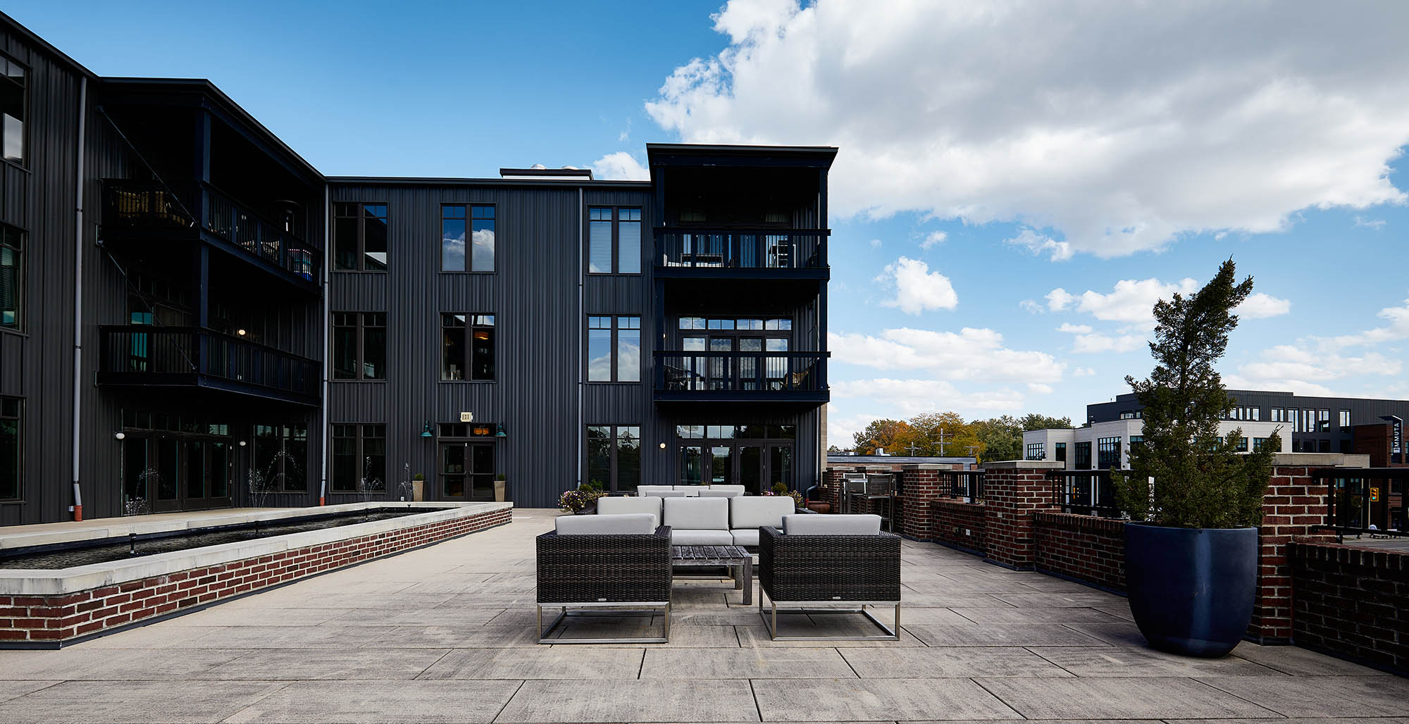 A patio with a table and chairs in front of a building.
