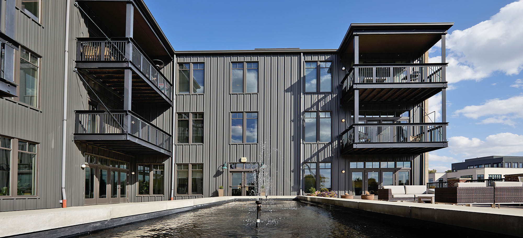 A building with balconies and a water feature.