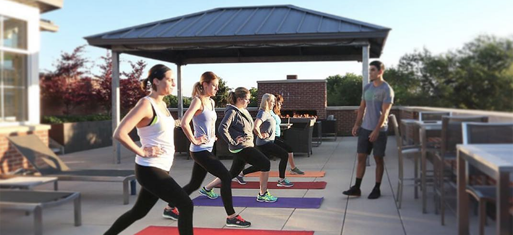 A group of people doing yoga on a rooftop.