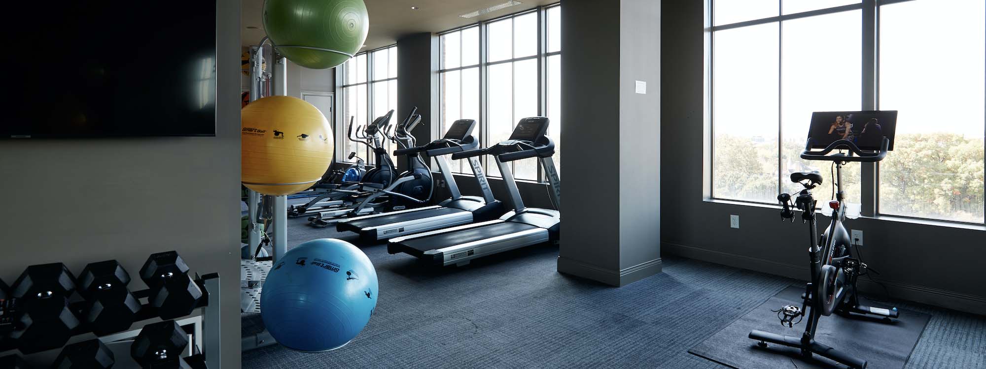 A gym room with a variety of exercise equipment.